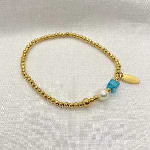 THE MAKERY GOLD BALL BRACELET WITH PEARL AND BLUE BEAD